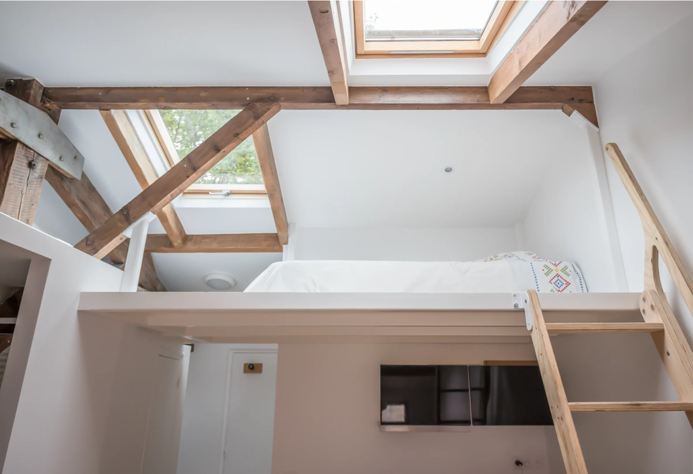 Attic studio with timber beams and mezzanine · 05